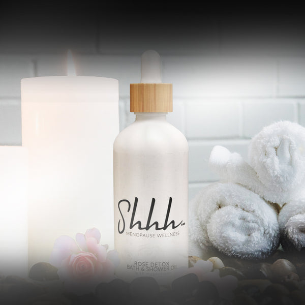Shhh… Menopause Wellness Rose Detox Bath & Shower Oil with magnesium. Beauty shot with candle.